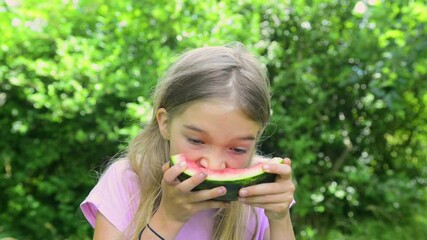 Wall Mural - Adorable blonde child girl eats a slice of watermelon outdoors