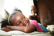 © Tetra Images - Black girl laying on sofa