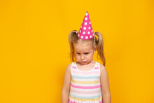 Unhappy Blonde Caucasian Girl With Sad Or Boring Face On Yellow Studio Background. Bad Birthday Party.