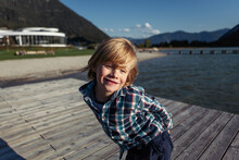 Portrait Of Smiling Boy Standing On Boardwalk At Achen Lake