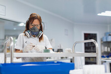 Confident Mature Female Technician Holding Marker While Looking At Pills In Lab