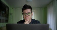 Male Hacker Working On A Computer For Cyber Attack While Green Binary Hacking Code Characters Reflect On His Face In Home