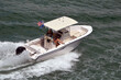 Angled overhead view of an open sport fishing boat with canvas covered canopy center console.