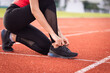 © EduLife Photos - Close up of a woman athelete runner ties shoelace before jogging workout in the city stadium. Healthy and rereation stock photo.