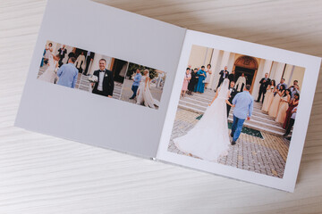 Open photobook with wrdding photo of beautiful couple on white wooden table