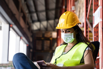 Young engineer worker wears mask and vest working in warehouse factory