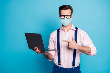 Sticker - Portrait of his he attractive healthy guy wearing gauze safety mask showing using laptop stay home stop influenza mers cov social distance pandemia isolated bright vivid blue color background