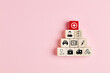 Health insurance concept. Health care icons on wooden blocks against pink background.