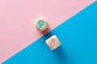 Male and female sex icons on wooden cubes on pink and blue background. Sex change, gender reassignment, transgender and sexual identity concept.