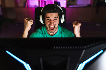 Image of excited man making winner gesture while playing video game