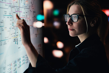 Wall Mural - digital monitor with public transport subway map. female standing at big display with advanced innov