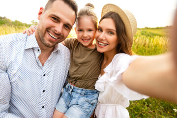 Wall Mural - Happy loving family taking selfie on a picnic outdoor