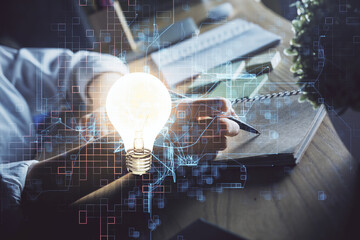 Poster - Drawing bulb over woman's hands taking notes background. Concept of idea. Double exposure