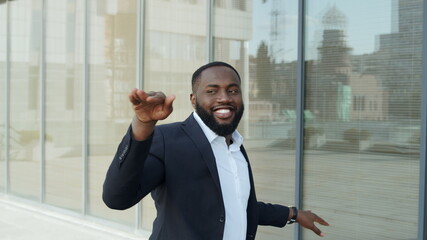 African businessman dancing in city. Business man celebrating success on street.