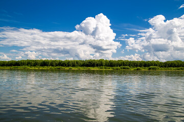 summer landscape, a cumulus cloud floats over the river