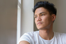 Face Of Handsome Asian Man Looking Outside The Window Indoors