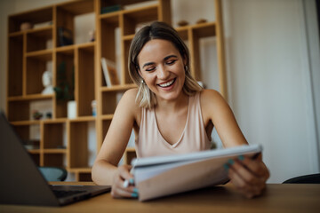 Wall Mural - People, education and business concept. Portrait of a smiling young woman with paper notebook.