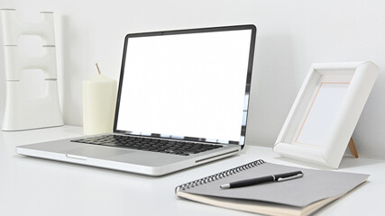 Modern decor of workspace with laptop and notebook on white background in home office.