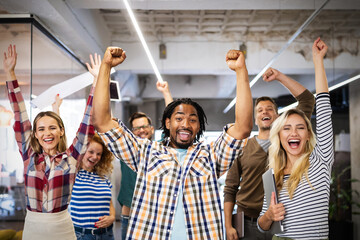 Group of successful happy business people in office celebrating profits