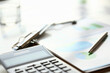 © H_Ko - Close up of calculator and folder lying on table near metal pen and financial documents