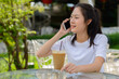 © Ranta Images - Happy young beautiful Asian woman talking on the phone at the coffee shop outdoors