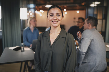 Smiling young businesswoman working in a modern office