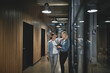© Flamingo Images - Smiling businesswomen talking together in an office hallway