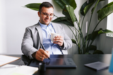 Smiling businessman using a graphics tablet