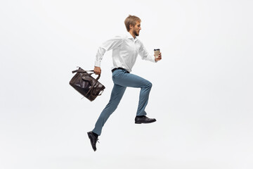 Coffee time. Man in office clothes running, jogging on white background like professional athlete, sportsman. Unusual look for businessman in motion, action with ball. Sport, healthy lifestyle