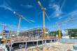 Large building site with foundations, cranes, scaffolding and partly finished buildings