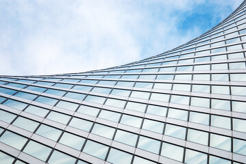 abstract modern architecture, glass building structure, wave shape building detail in blue sky