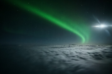 Wall Mural - Northern lights or Aurora Borealis above the clouds, view from plane. Night sky landscape