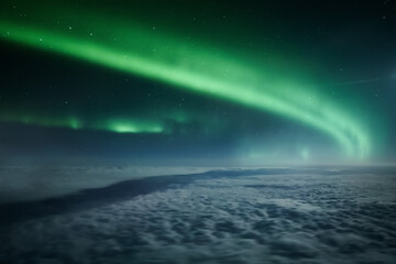 Wall Mural - Northern lights or Aurora Borealis above the clouds, view from plane. Night sky landscape