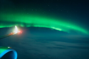 Wall Mural - Northern lights or Aurora Borealis above the clouds, view from plane. Night sky landscape