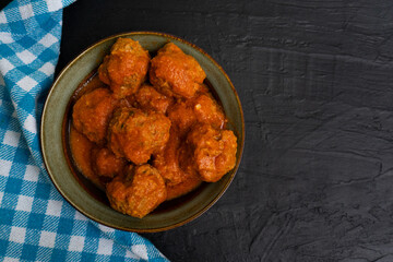 Wall Mural - Meatballs in red sauce on dark background