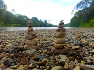 Two stone pyramids on a background of blue sky and river. The concept of balance, harmony and meditation