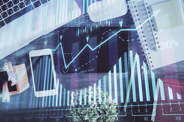 Double exposure of forex chart hologram over desktop with phone. Top view. Mobile trade platform concept.