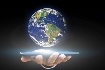 Canvas Print - environment concept. hand holding smartphone with earth on black background. elements of this image 