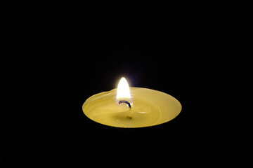 Wall Mural - Burning festive tea candle on a black background