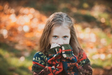 Wall Mural - Adorable happy girl. Posing. Little girl in autumn orange leaves. Little girl in the park. Happy child girl outdoors. Happy kid on a background of autumn.