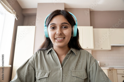 Photographie Indian teen girl college student teacher wearing headphones looking at web cam distance learn or teach online