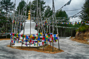 Wall Mural - Chorten and  prayer flags  in the snow repeating mantra