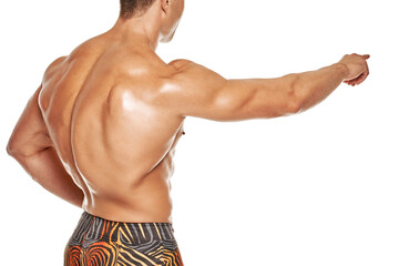 Back view of strong muscular bodybuilder pointing on white background