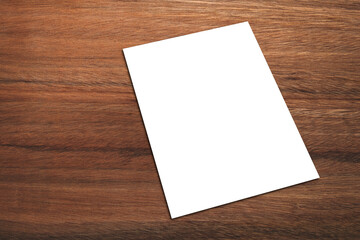 White promotion poster displayed or White paper laid on brown wood panels.  Shop promotion information for marketing announcements and details.