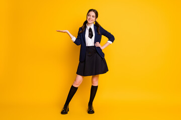 Canvas Print - Full length body size view of her she nice attractive cheerful cheery schoolgirl holding on palm copy empty blank space isolated on bright vivid shine vibrant yellow color background