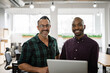 © JonoErasmus - Diverse businessmen smiling and using a laptop in an office
