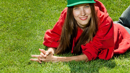 Wall Mural - young woman lying on the grass wearing color youth clothes, space
