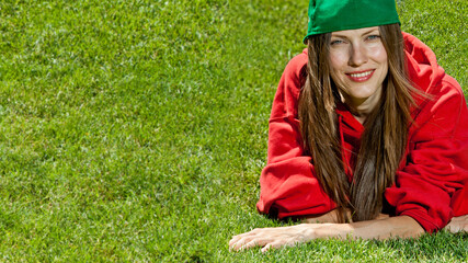 Wall Mural - young woman lying on the grass wearing color youth clothes, space