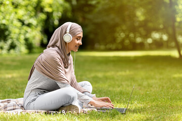 Wall Mural - Muslim girl watching movie on laptop at park