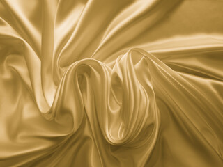 Beautiful smooth elegant wavy golden yellow satin silk. Luxury cloth fabric texture, abstract background design. Copy space. 